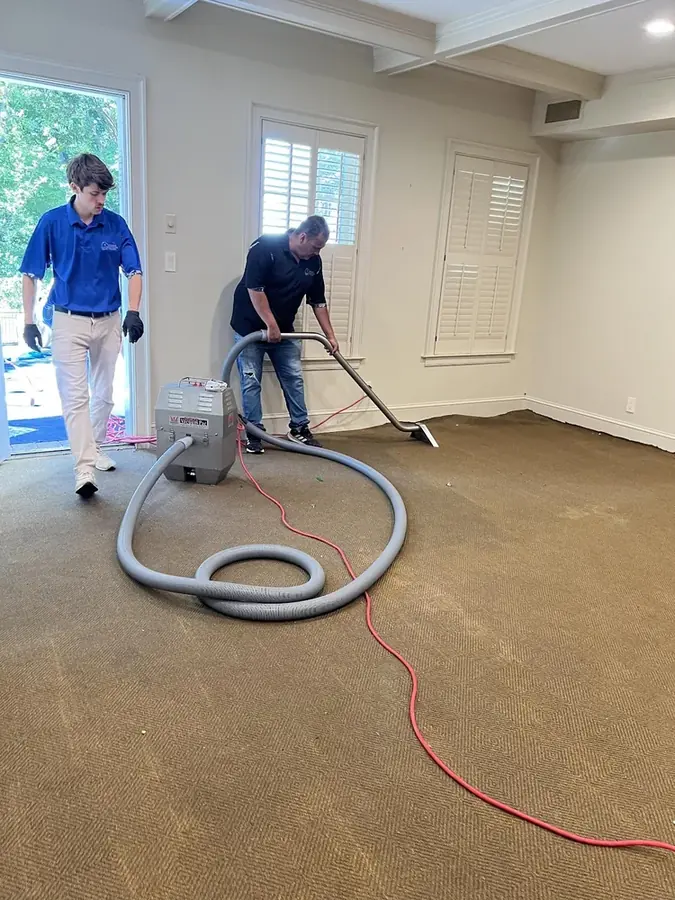 Technicians extracting water from a carpeted room in a Smyrna, GA home