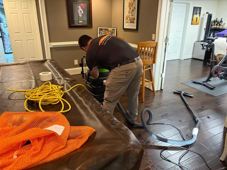 A crew member working a water-damaged room in a Smyrna, GA home